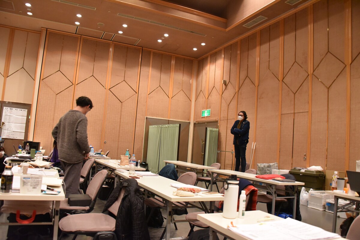 「桜姫東文章」の稽古の様子。稽古場の一番奥から全体を見つめる木ノ下裕一（右）に話しかける岡田利規。