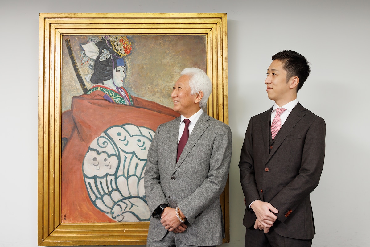 三代目中村時蔵の「女暫」の絵を見上げる五代目中村時蔵（左）と中村梅枝（右）。