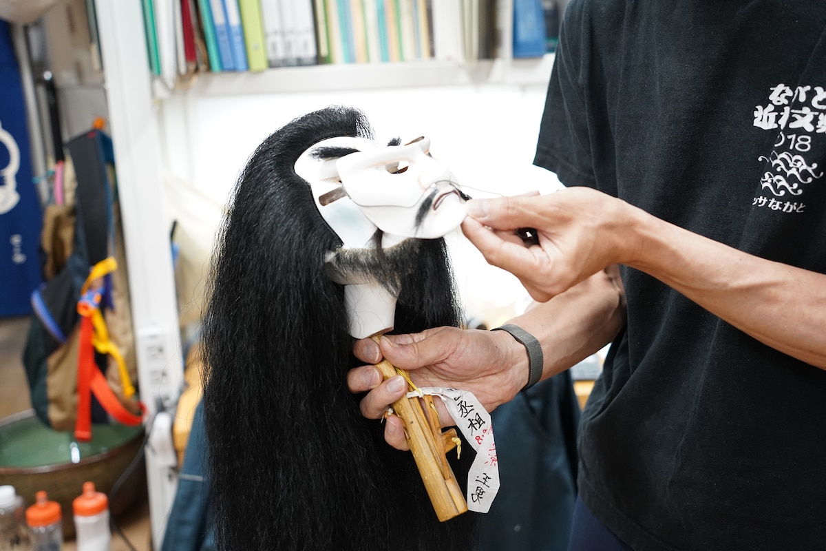 “丞相”のかしらにお面を付ける様子。