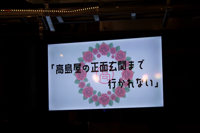 プロジェクターに投影された「高島屋の正面玄関まで行かれない」のタイトル。