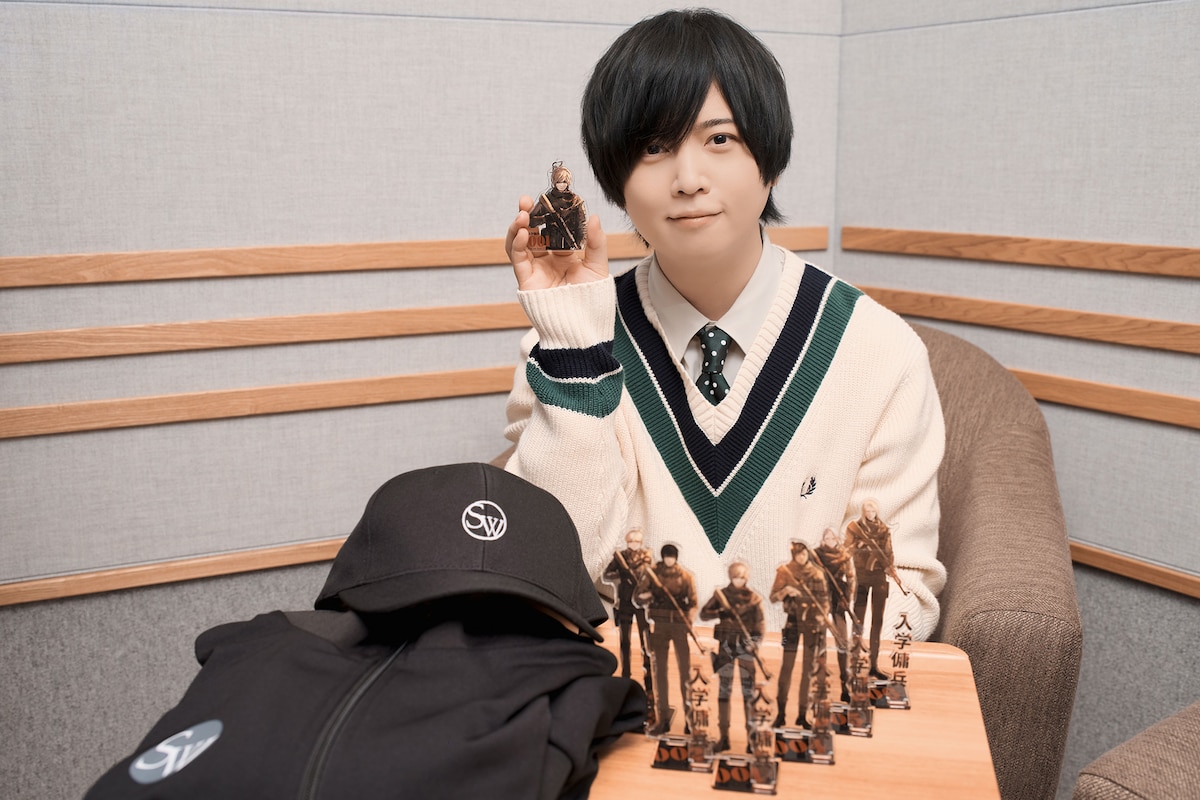 ポップアップストアで販売される「入学傭兵」グッズを手に持つ斉藤壮馬。
