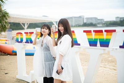 ビーチで乾杯するyuu(左)とhinako(右)。