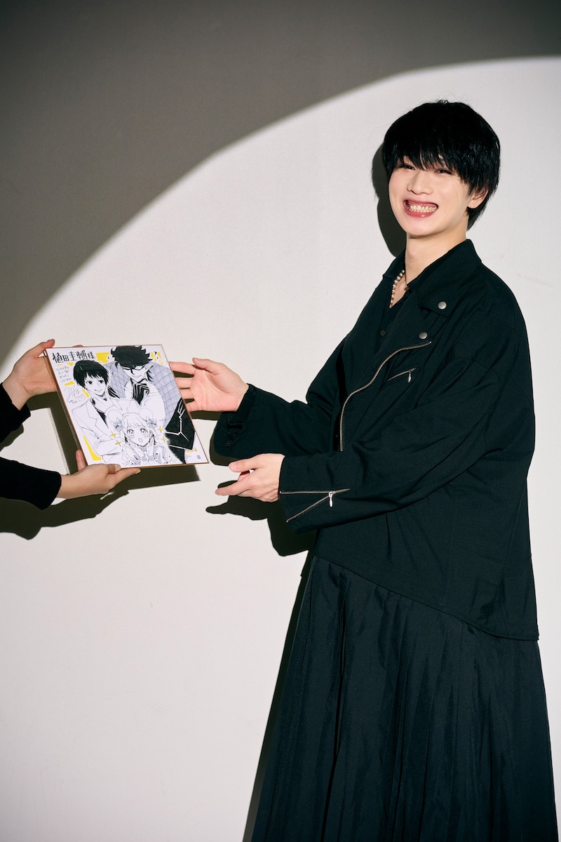 水帆かえるからイラスト色紙を受け取る植田圭輔。