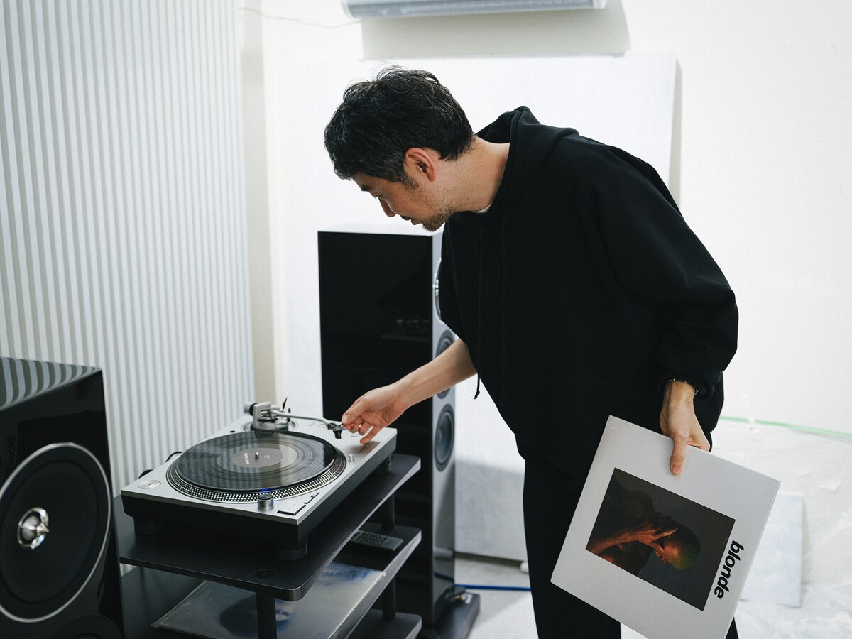 レコードに針を落とす長場。