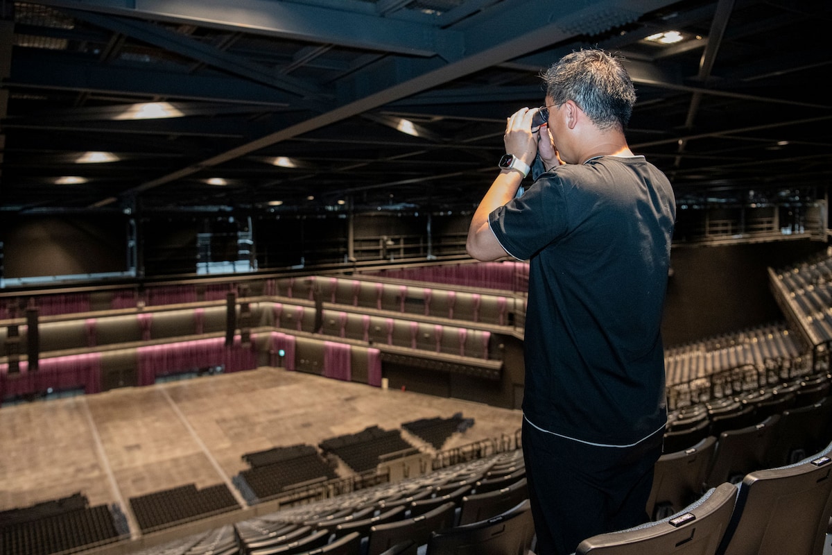 編集部員が持参したVixenの防振双眼鏡・ATERA H10×21を覗き込む古家さん。