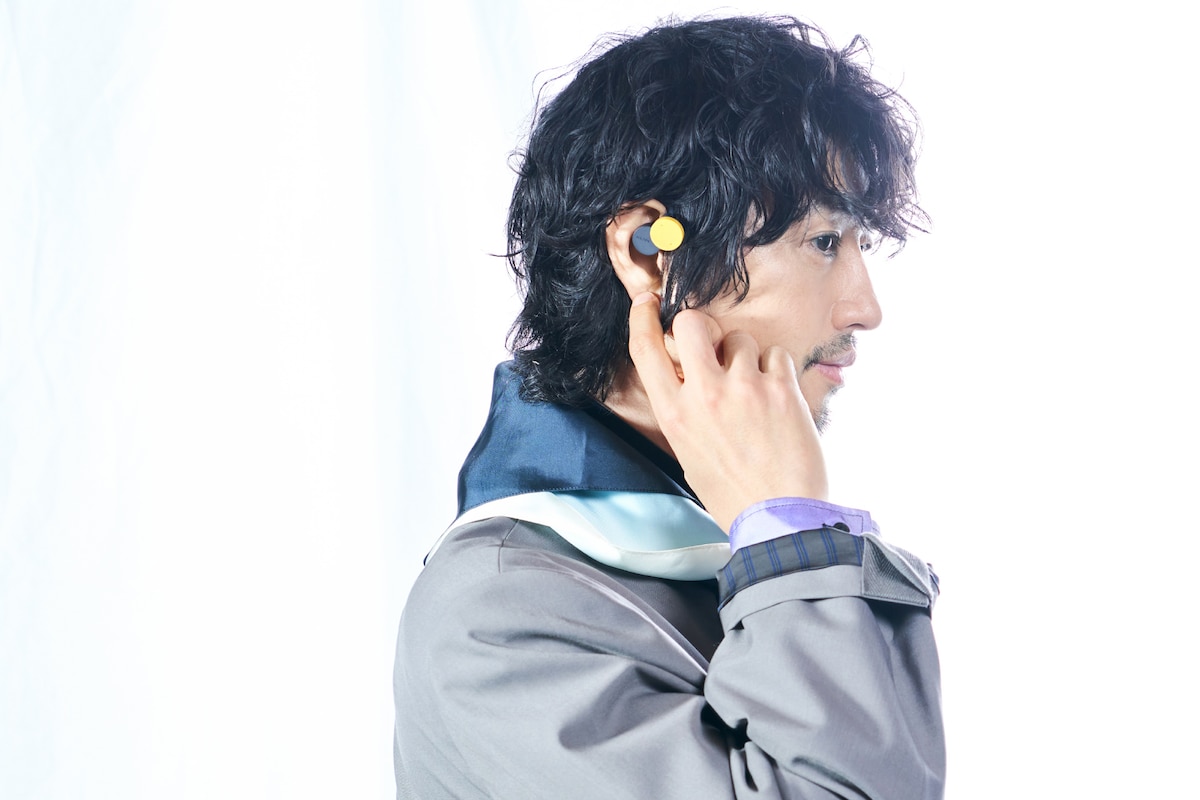 「nwm DOTS」マスタードイエローを装着した斎藤工。「nwm DOTS」は付属の専用チップを付け替えることで自分の耳に合うカスタマイズが可能。片耳約8gと軽量で疲れにくいのもポイント