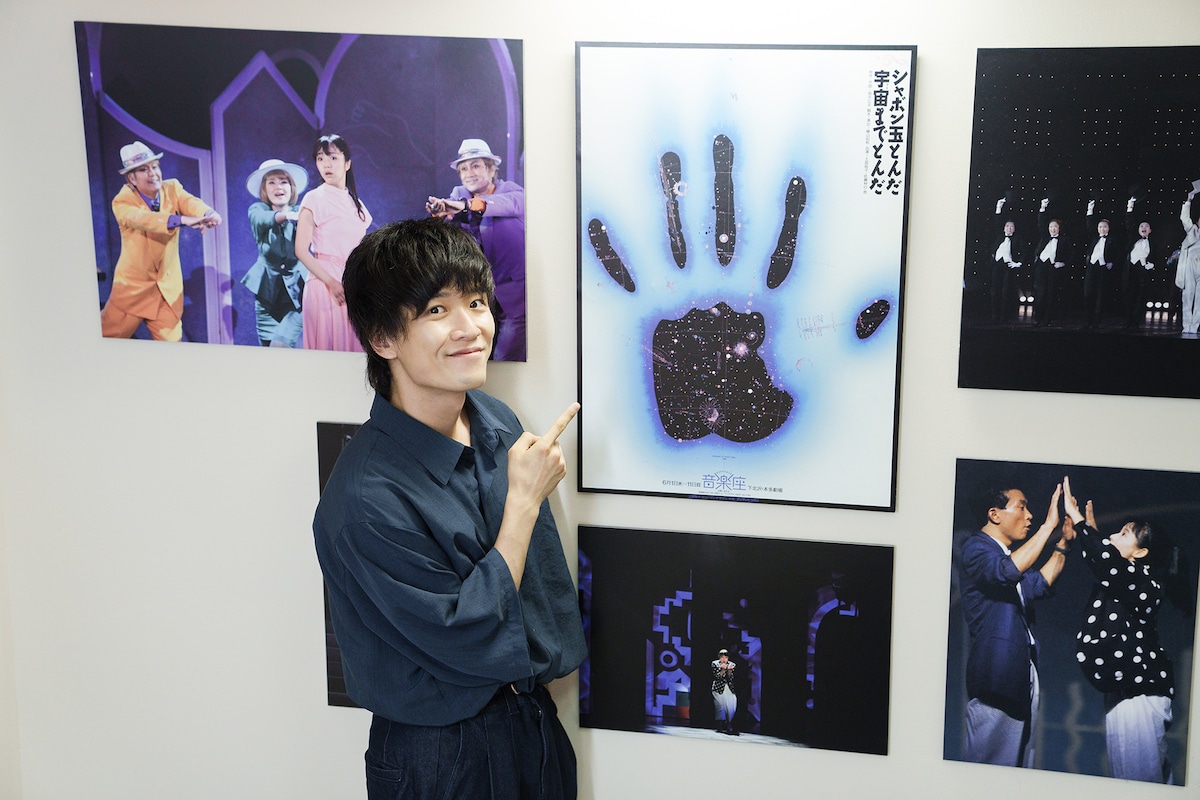 音楽座ミュージカル「シャボン玉とんだ宇宙（ソラ）までとんだ」1989年公演のポスターを指差す畠中祐。