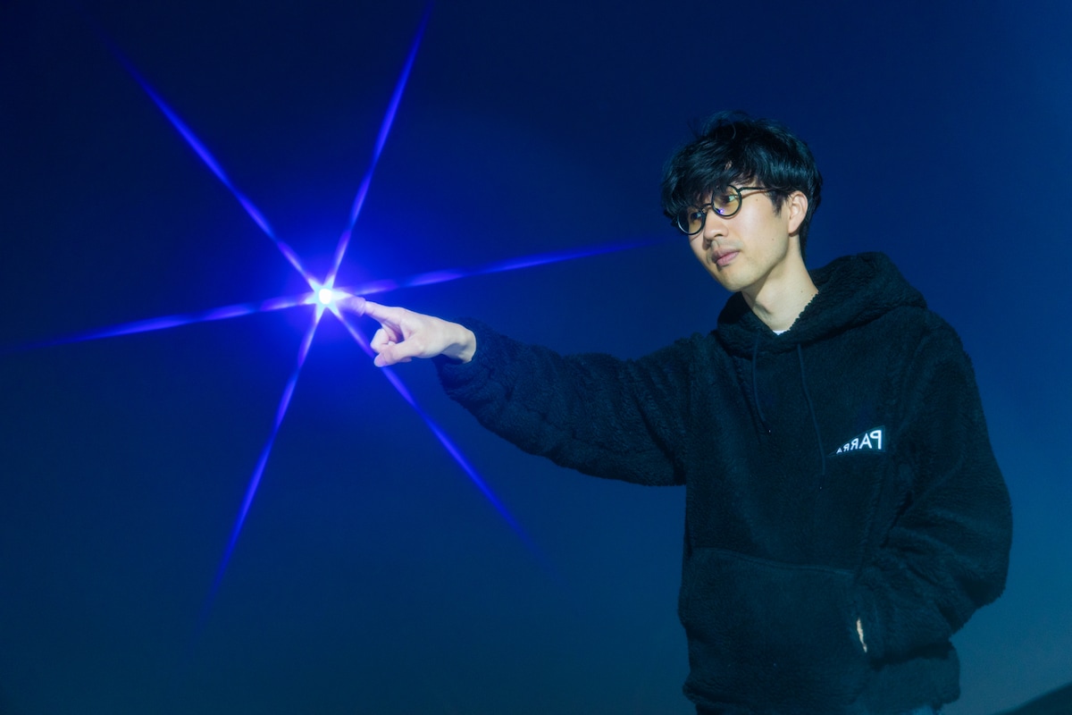 宇宙人の能力によって指先から不思議な光を放つ西山。