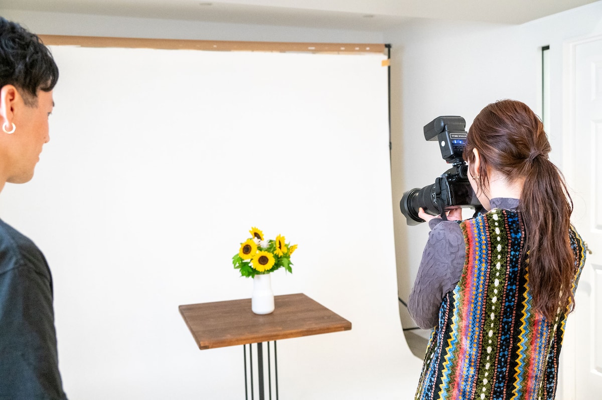 デジタル一眼カメラ「LUMIX DC-S5M2」と、「エネループ プロ」をセットしたストロボ「Neewer TT560」を使って撮影するセントチヒロ・チッチ。（撮影：音楽ナタリー編集部）