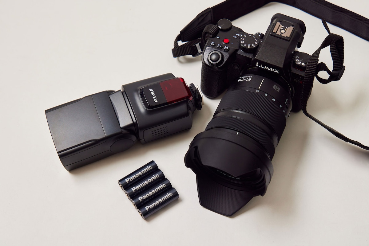Panasonic製のデジタル一眼カメラ「LUMIX DC-S5M2」、乾電池で駆動するクリップオンストロボ「Neewer TT560フラッシュスピードライト」、「エネループ」のハイエンドモデル「エネループ プロ」。