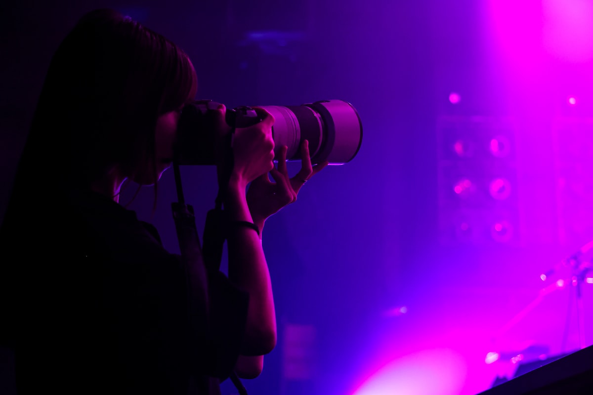 ステージに向かってカメラを構えるカメラマン。