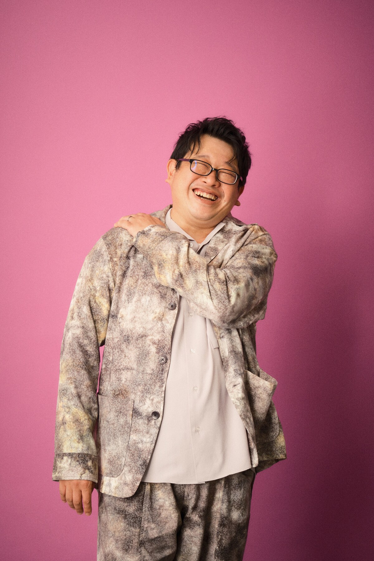 さまざまなポーズを模索中、「肩痛いポーズになっちゃった！」と笑顔を見せる毛利亘宏。