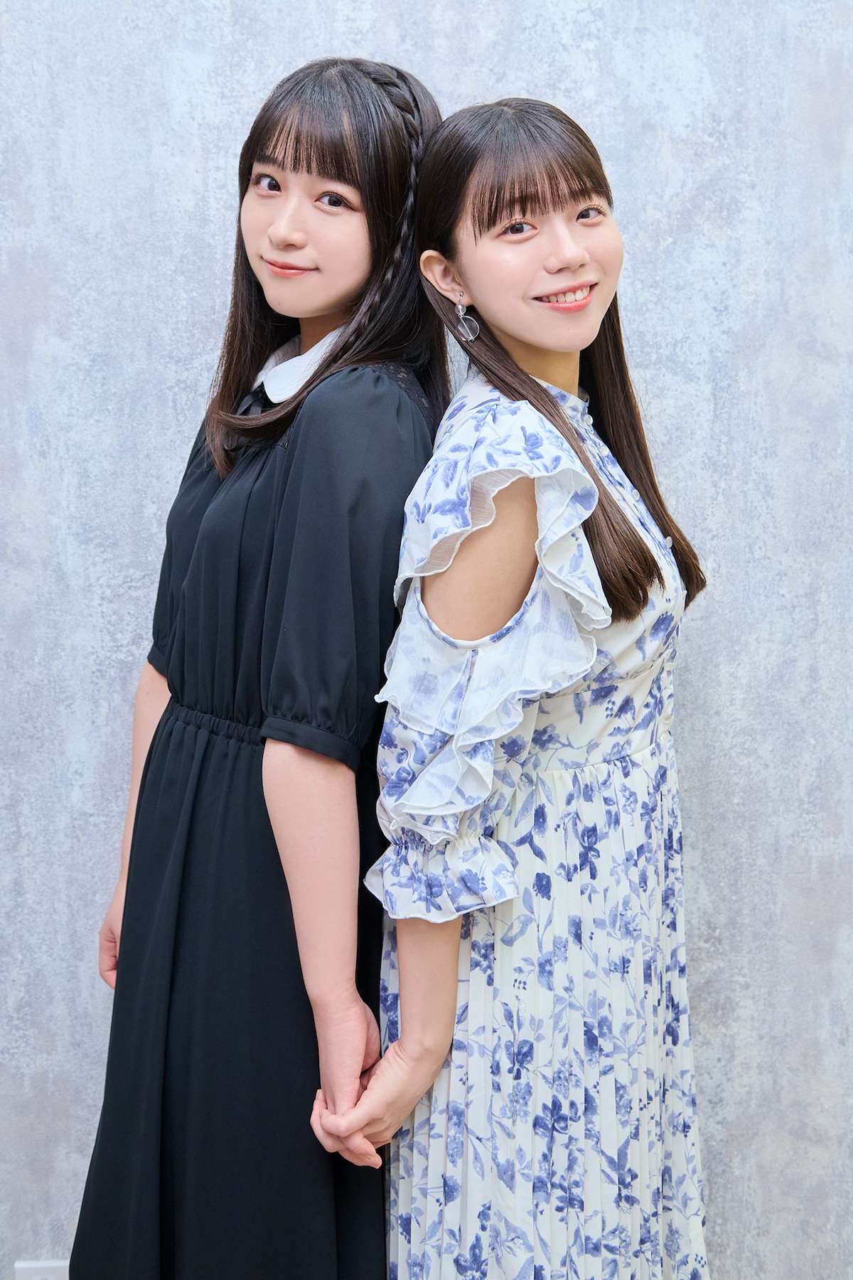 背中合わせで手をつなぐ原田清花と工藤理子。