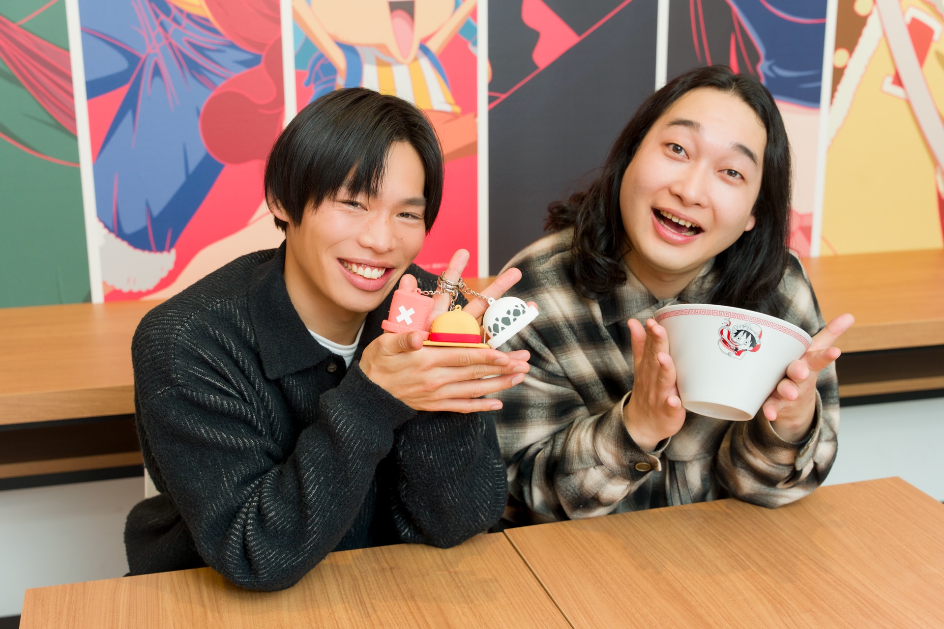 「ONE PIECE CAFE GENE」のグッズを手に持つかが屋。