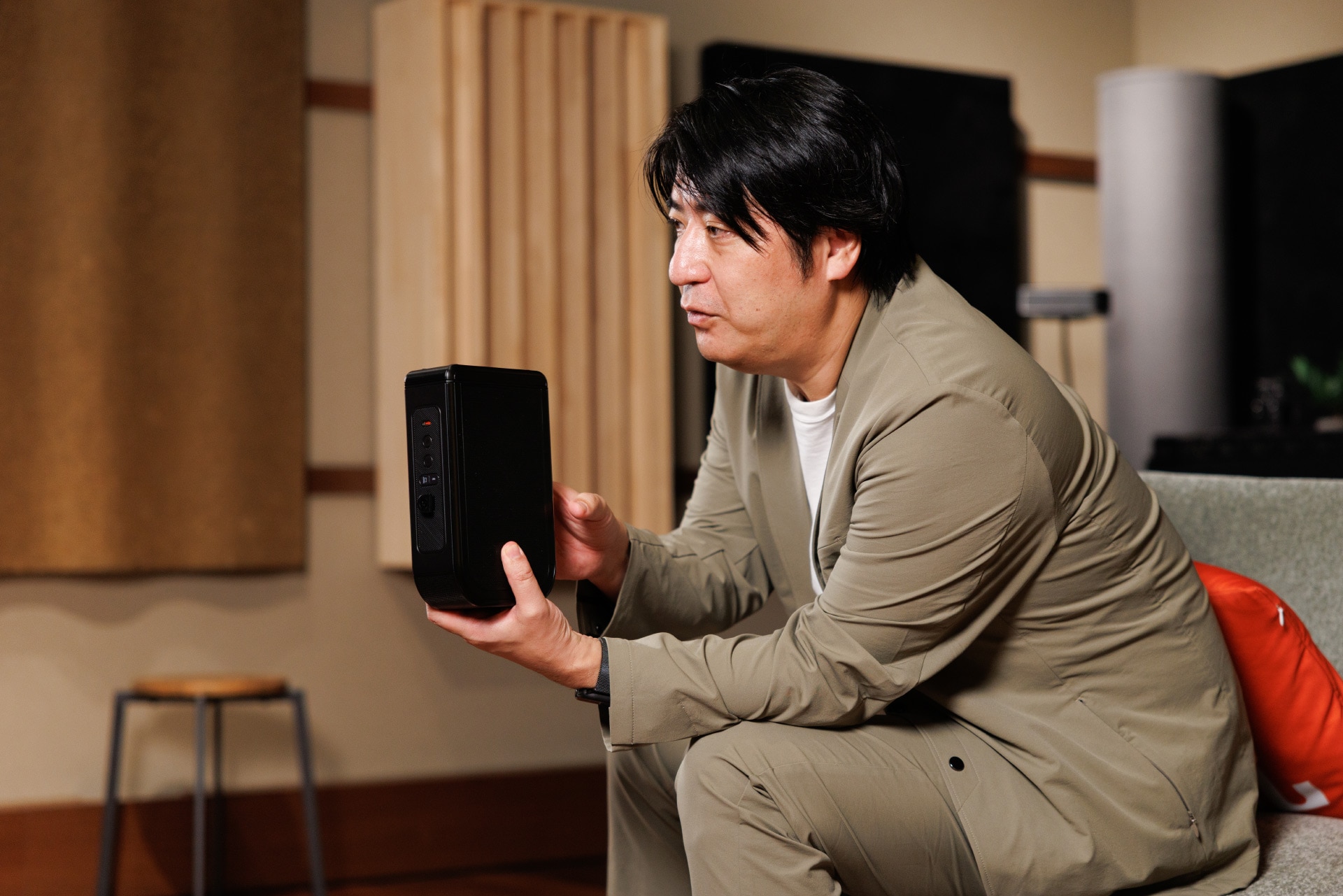 「JBL BAR 1300MK2」のリアスピーカーを手に持つ佐久間宣行