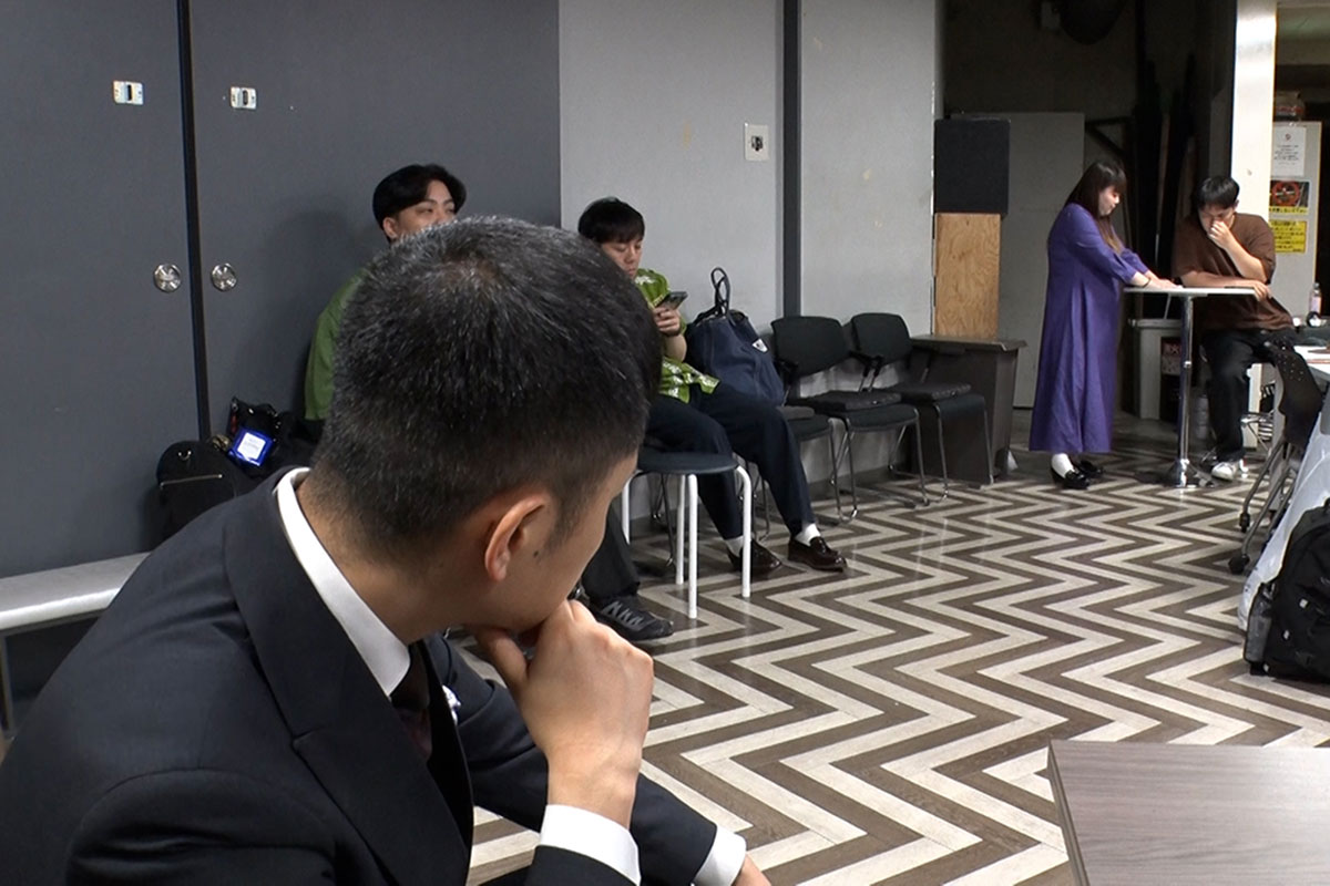 芸人仲間たちを観察する渡辺銀次