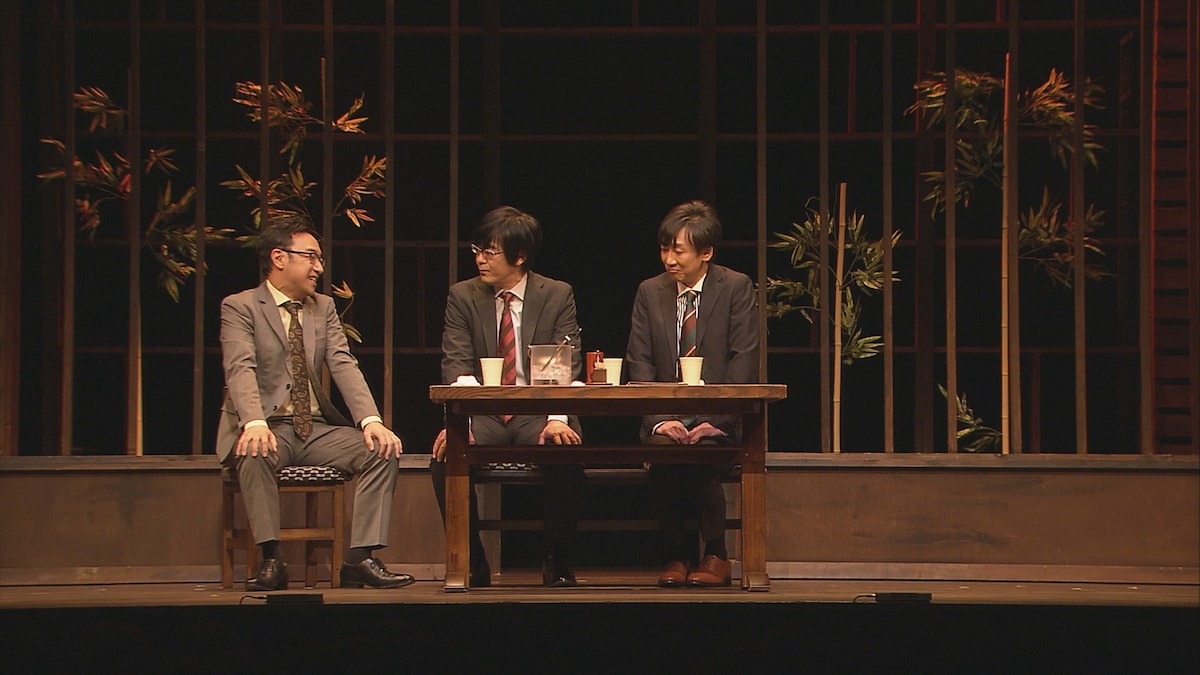 「第21回東京03単独公演『人間味風』」 のワンシーン。コント「部長のいい話」で角田が部長、豊本と飯塚も部下を持つ上司を演じている。