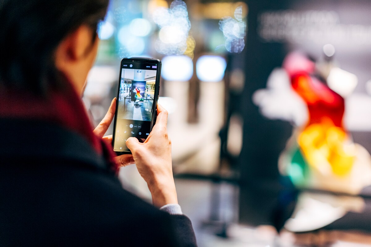 映画館に展示された「HIKARU UTADA SCIENCE FICTION TOUR 2024」の衣装を撮影する観客。