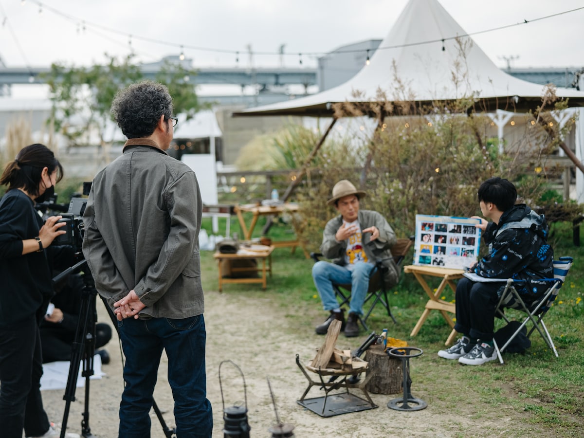 オープニング収録で“奥田民生トーク”をするたけだバーベキューと遠山大輔（グランジ）をカメラ横で見つめる奥田民生。